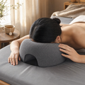 Woman lying face-down on a gray memory foam pillow with a breathing cutout